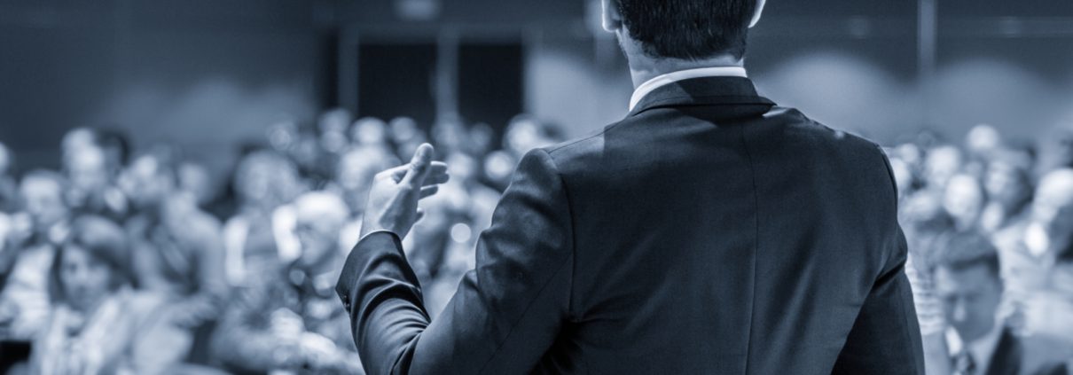 Ein Präsentations-Coach im Anzug begeistert mit seinem Vortrags-Training im Power-Workshop: Fit und sicher für den nächsten Auftritt am 04.09.2025, während das Publikum aufmerksam in Reihen zuhört.